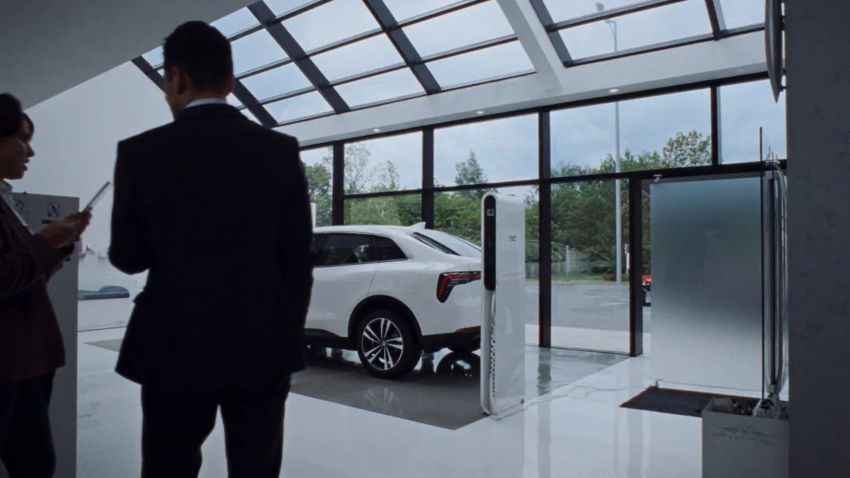 Autohaus mit Elektrofahrzeug und DC-Ladesäule im Showroom